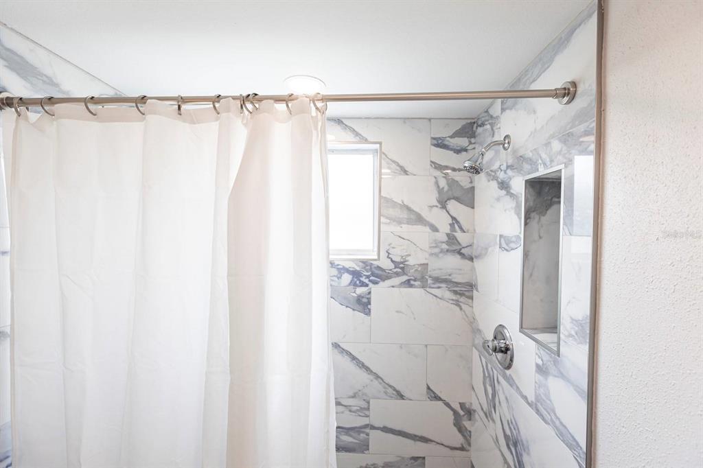 6020 Midnight Pass Road, Unit 52A Sarasota, FL 34242 - Photo 10 of 28 a bathroom with a shower curtain and a sink