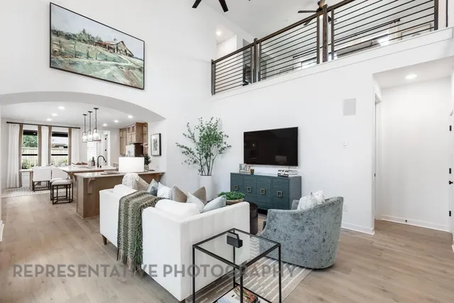 a living room with furniture a flat screen tv and a table