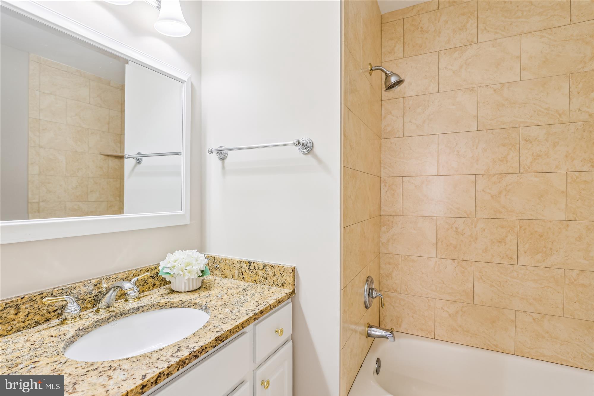 7708 Shootingstar Drive Springfield, VA 22152 - Photo 31 of 62 a bathroom with a granite countertop sink a mirror and a bathtub