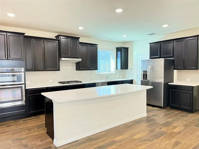 a kitchen with stainless steel appliances a refrigerator and a stove