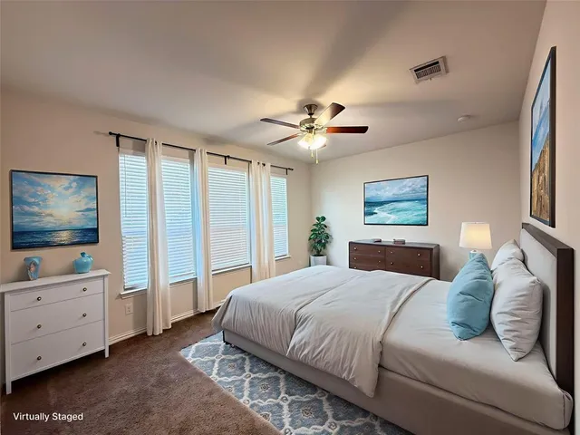 a bedroom with a large bed a flat tv screen and a dresser