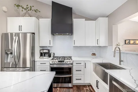 a kitchen with stainless steel appliances a stove a sink and a refrigerator