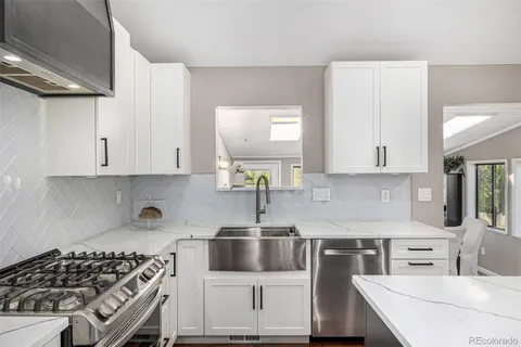 a kitchen with stainless steel appliances a sink a stove and cabinets