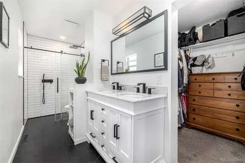 a bathroom with a sink vanity granite tub and shower