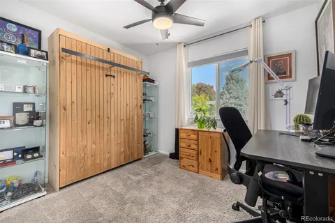 a view of a workspace with furniture and a window