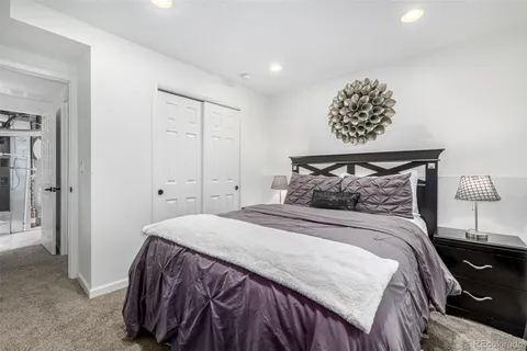 a bedroom with a bed a rug and a painting