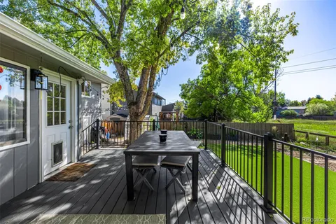 a view of a patio with table and chairs with wooden floor and fence