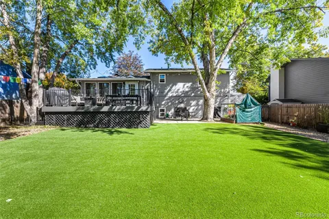 a view of a house with backyard and a tree