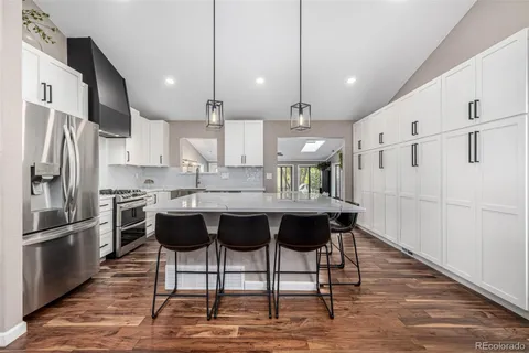 a kitchen with stainless steel appliances kitchen island granite countertop a refrigerator a stove a sink and a microwave