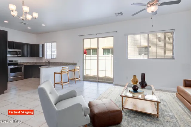 a living room with furniture kitchen view and a large window