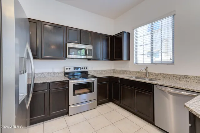 a kitchen with stainless steel appliances granite countertop a stove sink and microwave