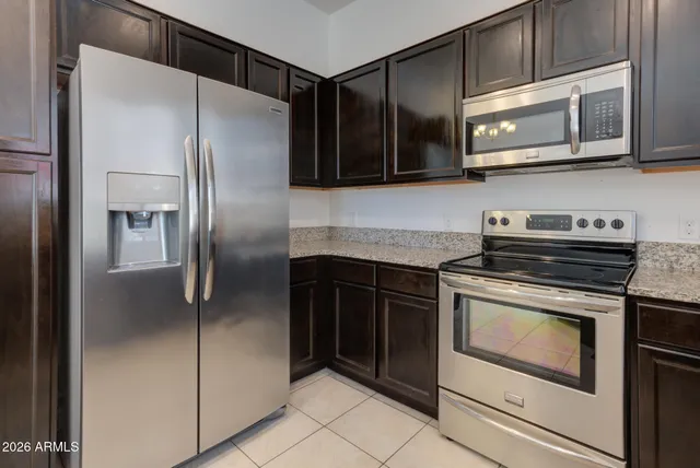 a kitchen with stainless steel appliances granite countertop a stove microwave and refrigerator