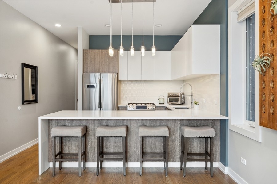 2437 West Haddon Avenue, Unit 2 Chicago, IL 60622 - Photo 5 of 14 a kitchen with stainless steel appliances granite countertop a table chairs sink and cabinets