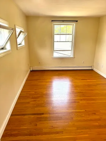 a view of a room with wooden floor and a window