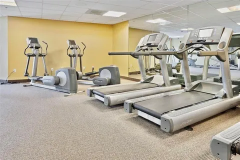 a living room with furniture gym equipment and a table