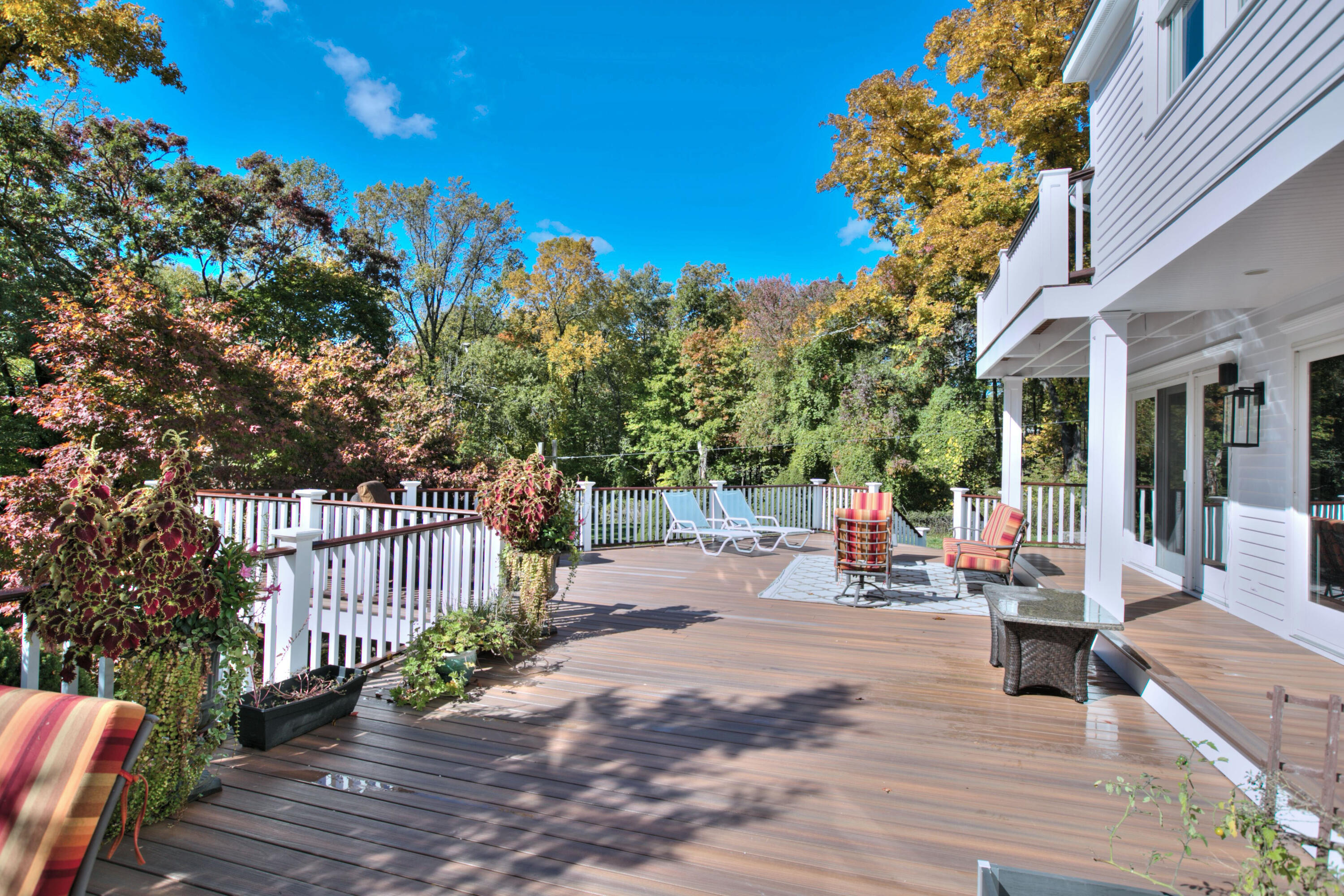 970 Ponus Ridge Road New Canaan, CT 06840 - Photo 32 of 39 a view of a patio with dining table and chairs with wooden fence and plants