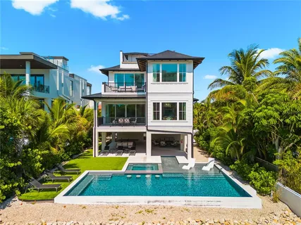 a view of a swimming pool with lawn chairs under an umbrella