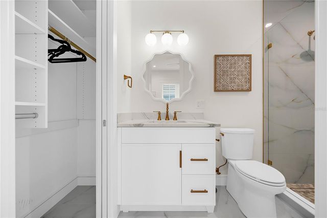 a bedroom with a bed a flat screen tv and a large window