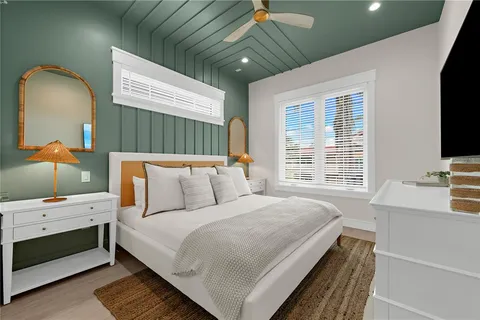 a view of a white building with a yard and potted plants