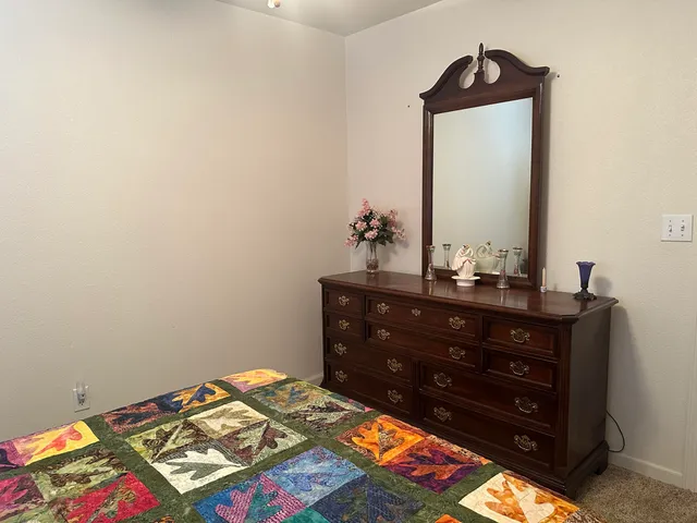 a bedroom with a bed and a mirror on dresser