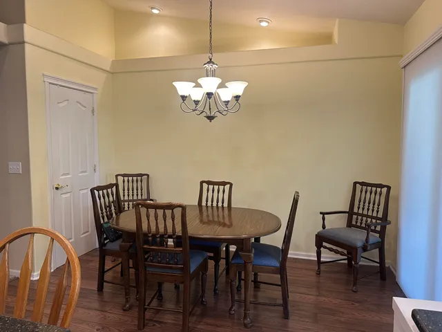 a view of a dining room with furniture a chandelier and wooden floor