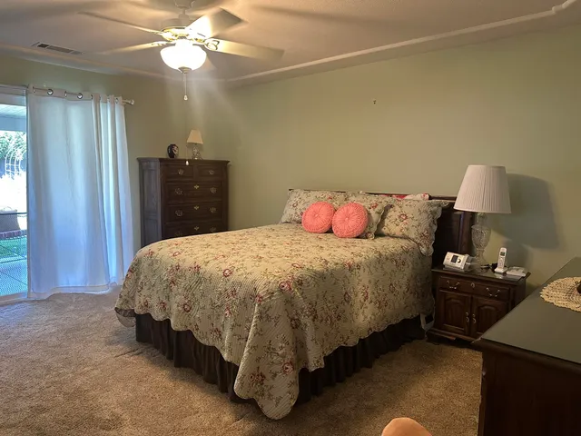 a spacious bedroom with a bed and a lamp