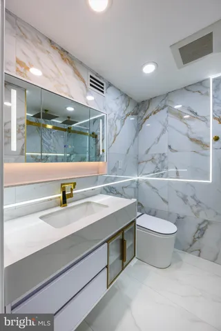 a bathroom with a sink a toilet and shower