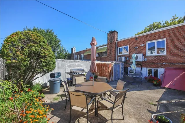 a backyard of a house with table and chairs