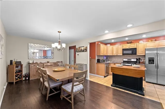 a kitchen with stainless steel appliances a dining table and chairs