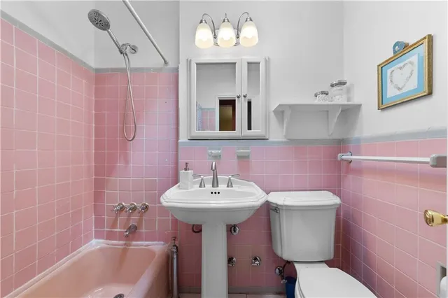 a bathroom with a sink mirror toilet and bathtub