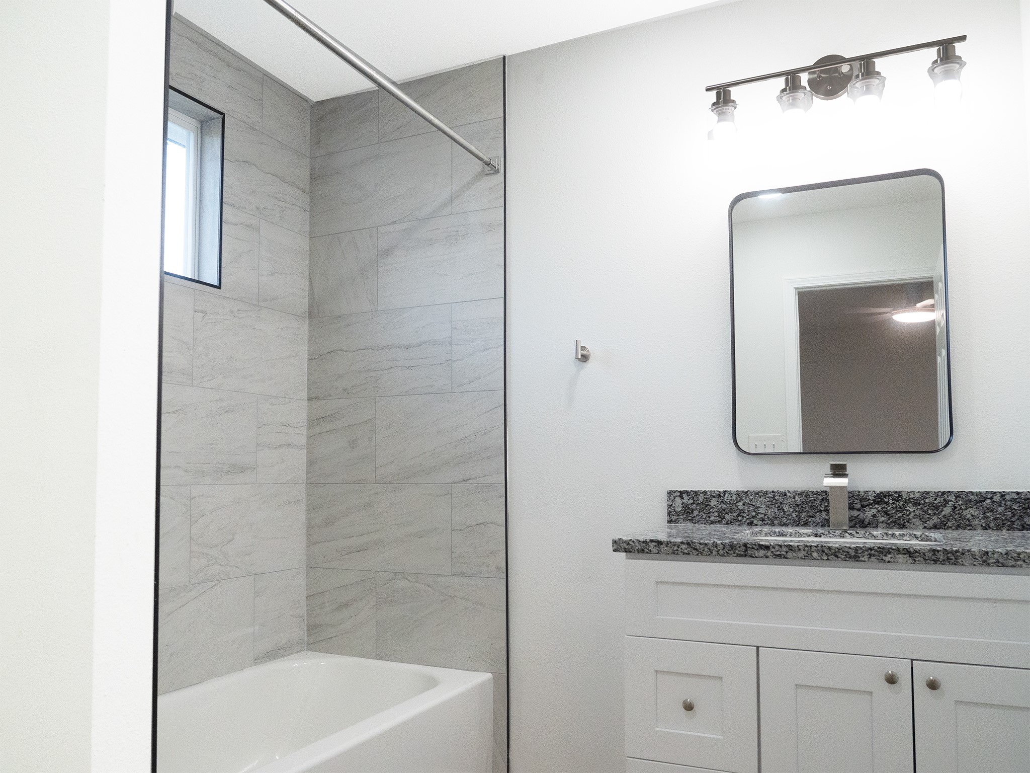 37 Road 5102, Unit L Cleveland, TX 77327 - Photo 9 of 29 a bathroom with a granite countertop sink a mirror and shower