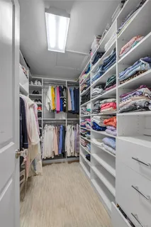 a view of walk in closet with clothes and shoes