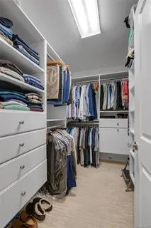 a view of walk in closet with clothes and shoes