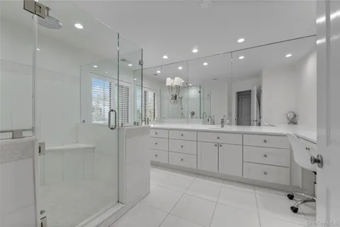 a bathroom with a double vanity sink mirror and shower