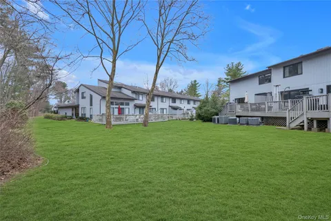 a view of a house with backyard and a tree