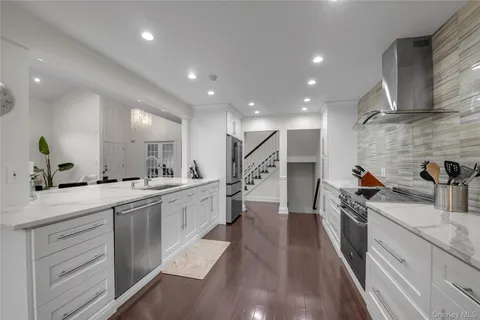 a kitchen with a sink stainless steel appliances a counter top space and cabinets