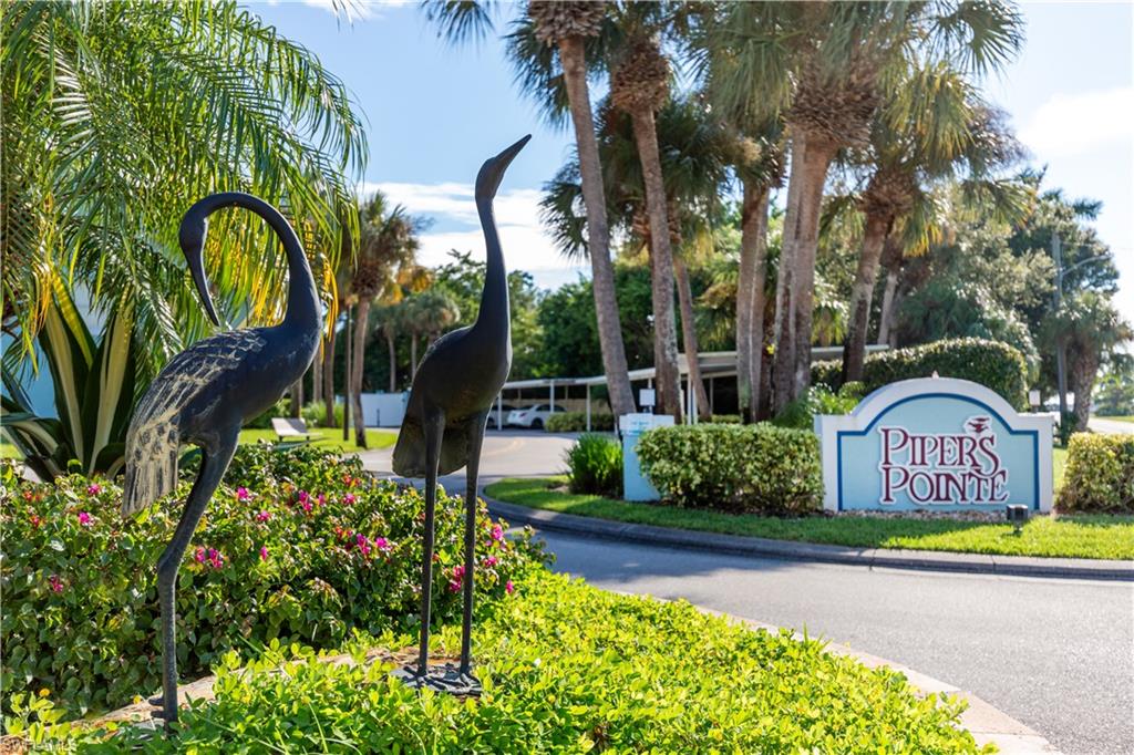 137 Wading Bird Circle, Unit F101 Naples, FL 34110 - Photo 15 of 16 a front view of multi story residential apartment building with yard and sign board
