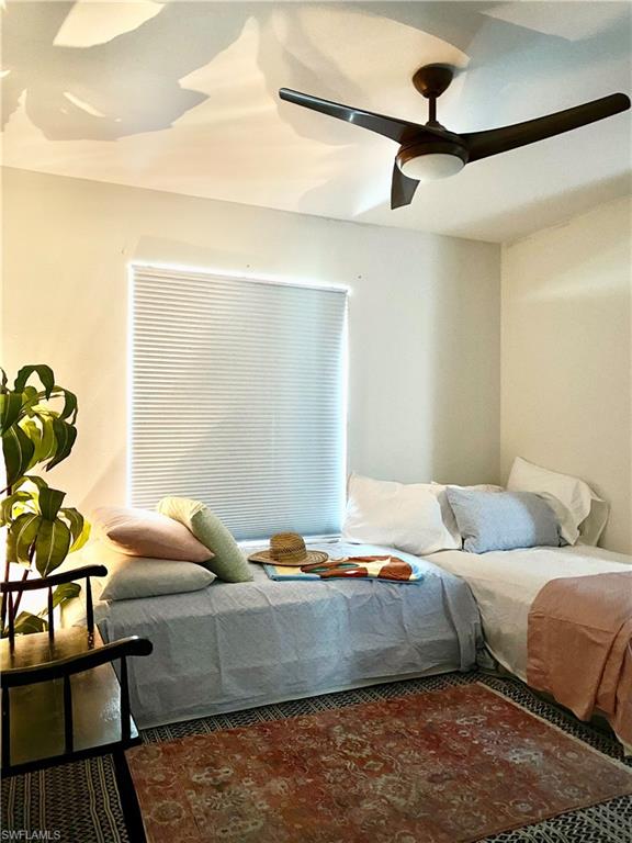 137 Wading Bird Circle, Unit F101 Naples, FL 34110 - Photo 7 of 16 a bedroom with a bed and wooden floor