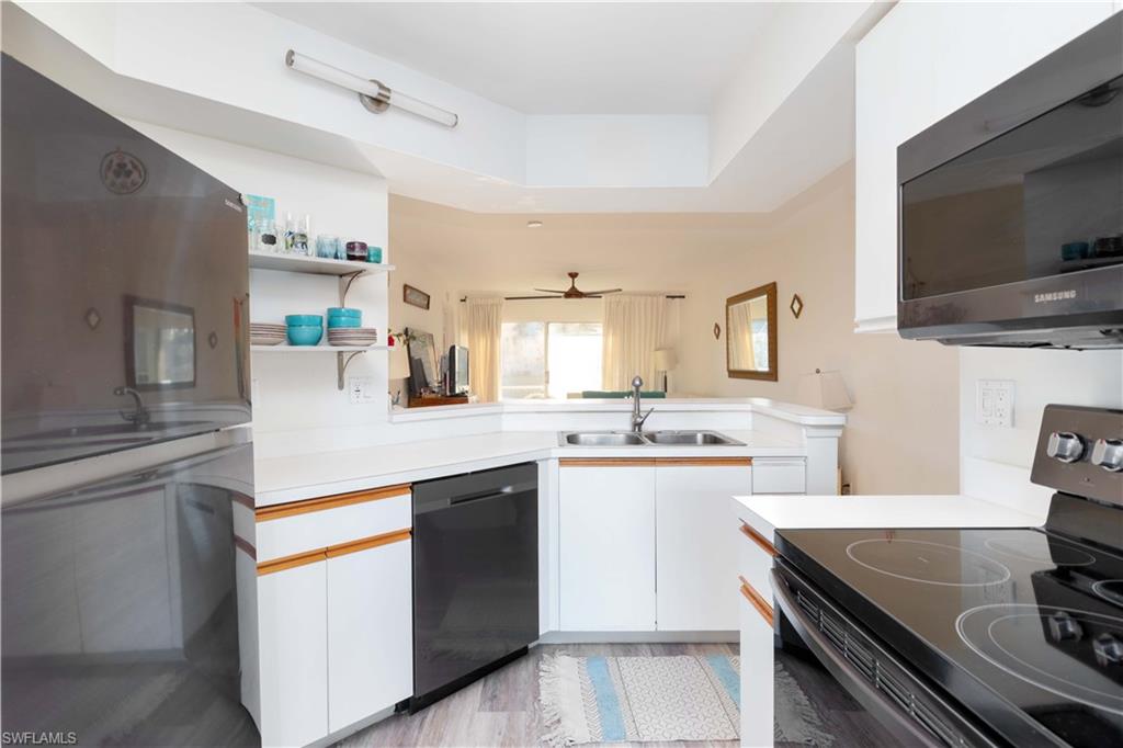 137 Wading Bird Circle, Unit F101 Naples, FL 34110 - Photo 9 of 16 a kitchen with stainless steel appliances a sink stove and refrigerator