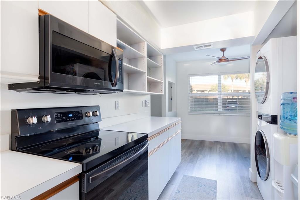 137 Wading Bird Circle, Unit F101 Naples, FL 34110 - Photo 10 of 16 a kitchen with a stove and a microwave