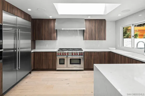 a kitchen with stainless steel appliances a stove a sink and a refrigerator