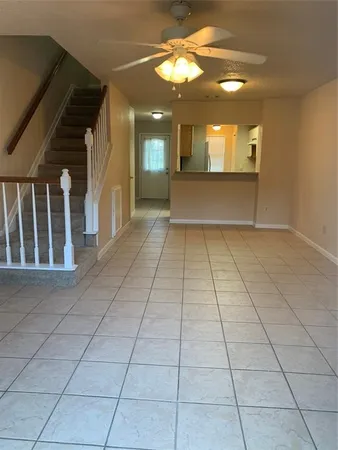 a view of a hallway with wooden floor and a kitchen view