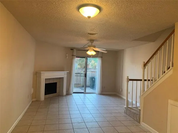 a view of an empty room with window and fire place