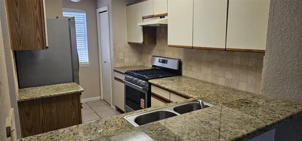 a kitchen with stainless steel appliances granite countertop a stove and a refrigerator