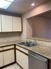 a kitchen with granite countertop sink and cabinets