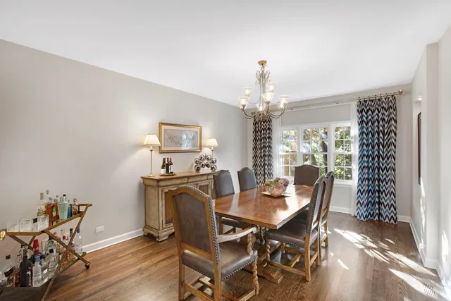 a view of a dining room with furniture a chandelier and wooden floor