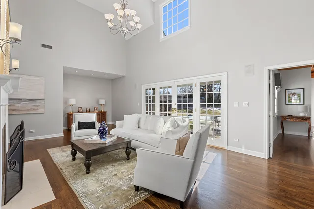 a living room with furniture a dining table and a fireplace with wooden floor