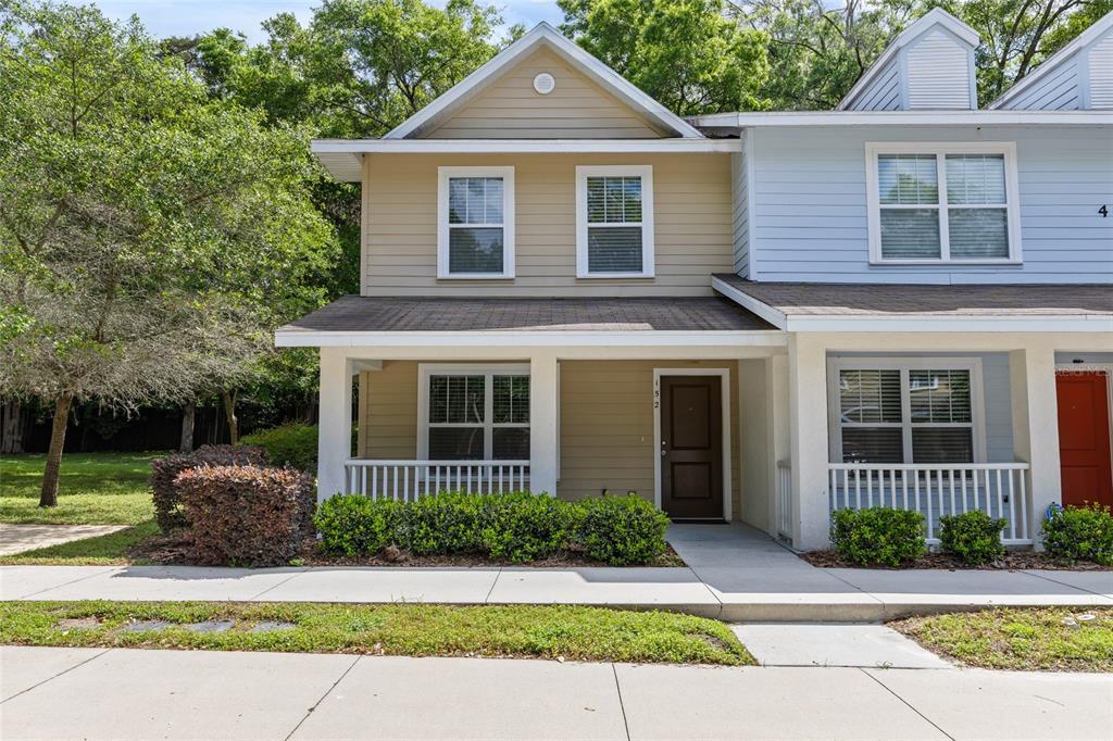 a front view of a house with a yard and potted plants