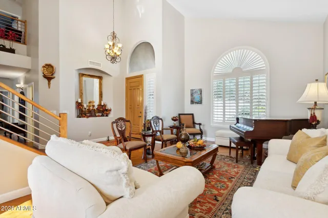 a living room with furniture chandelier and a large window