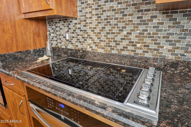 a kitchen with stainless steel appliances granite countertop a sink dishwasher stove and refrigerator with wooden floor